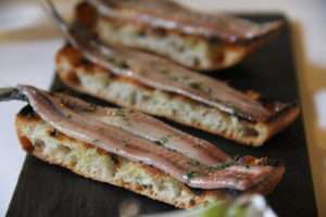 Grilled anchovy fillets on flatbread - Photo by Amaia Zeberio